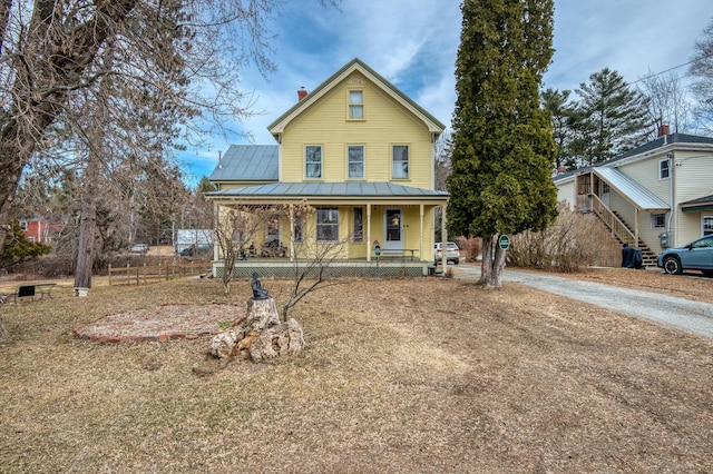 27 Pine St, Eustis, ME 04936 - view of front facade featuring a porch, metal roof, a chimney, concrete driveway, and a standing seam roof