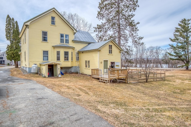 27 Pine St, Eustis, ME 04936 - rear view of house with metal roof, a deck, a lawn, and a standing seam roof