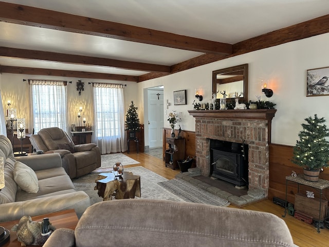 living room featuring beamed ceiling, wood finished floors, and wainscoting