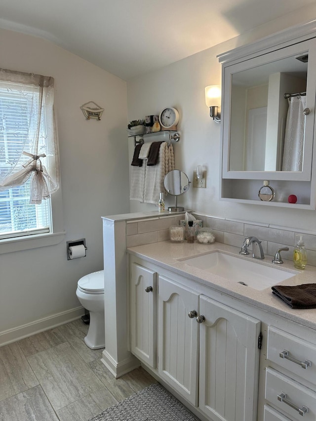 bathroom with wood finished floors, vanity, and toilet