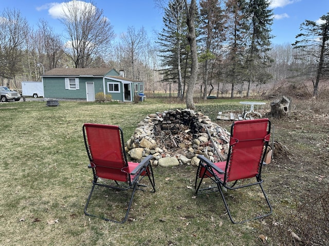 view of yard featuring an outbuilding and an outdoor fire pit