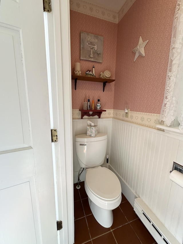 bathroom with wallpapered walls, a wainscoted wall, tile patterned floors, toilet, and a baseboard radiator