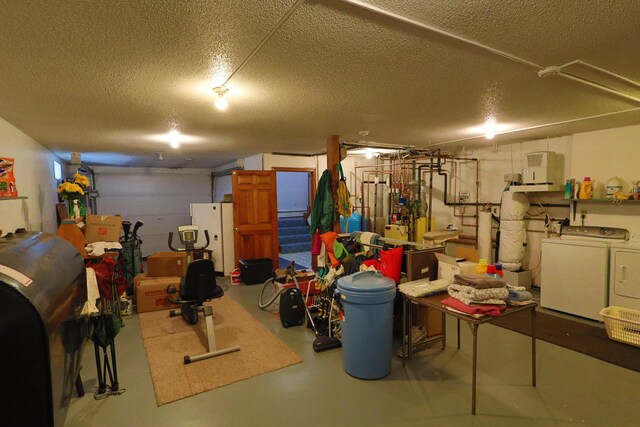garage featuring washing machine and clothes dryer and freestanding refrigerator