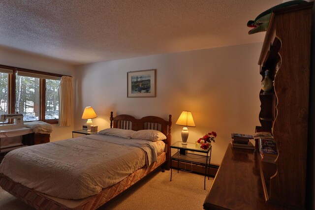 bedroom featuring a baseboard radiator, carpet, and a textured ceiling