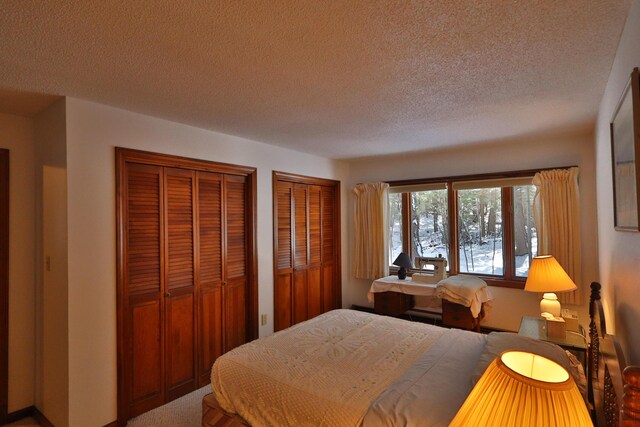 bedroom featuring a textured ceiling and multiple closets
