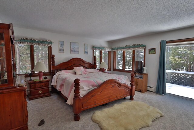 bedroom featuring baseboard heating, light carpet, and a textured ceiling
