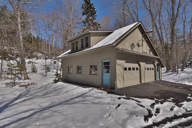 snow covered property featuring a detached garage
