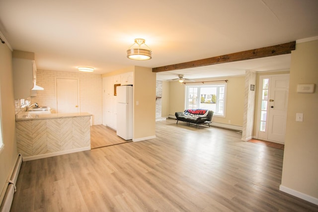 living area with light wood-style flooring, a baseboard radiator, and baseboards
