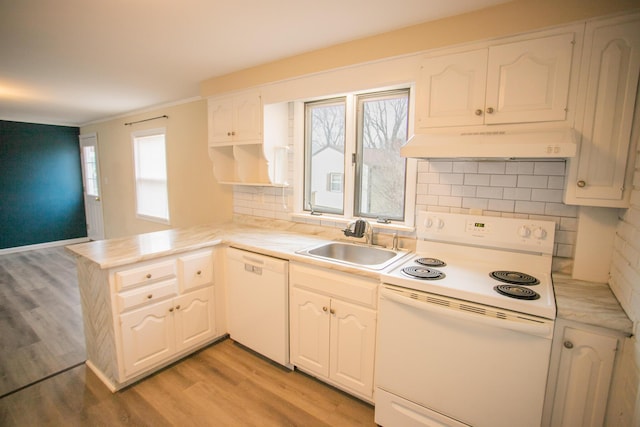 kitchen featuring a sink, white appliances, a peninsula, under cabinet range hood, and light wood finished floors