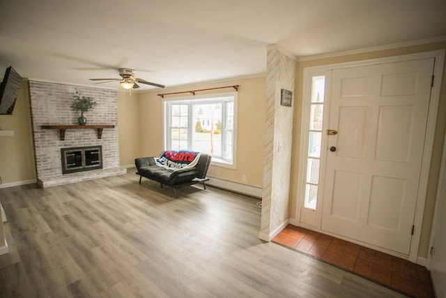 entryway with ornamental molding, baseboards, a ceiling fan, and wood finished floors