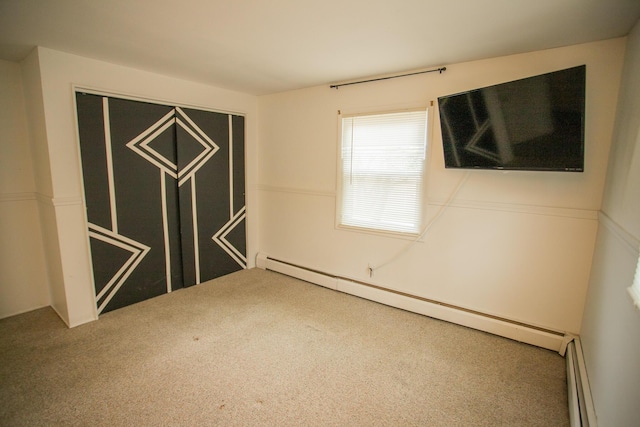 carpeted spare room featuring baseboard heating