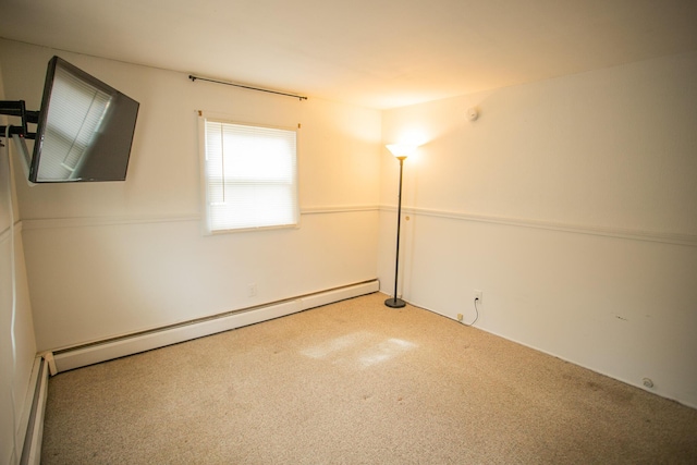 unfurnished room featuring baseboard heating and carpet