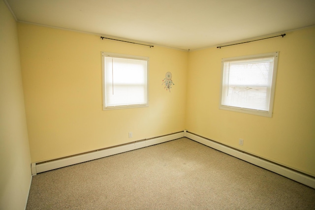 empty room featuring plenty of natural light and baseboard heating