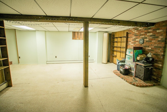 finished below grade area with a baseboard heating unit, carpet, and a drop ceiling