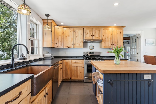 kitchen with under cabinet range hood, stainless steel appliances, a sink, pendant lighting, and butcher block countertops