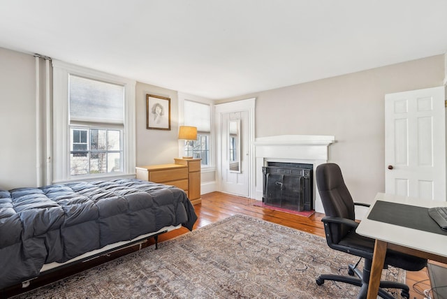 bedroom featuring wood finished floors and a fireplace