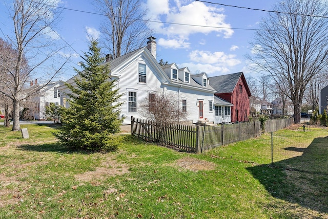 rear view of property featuring a residential view, a lawn, a chimney, and fence