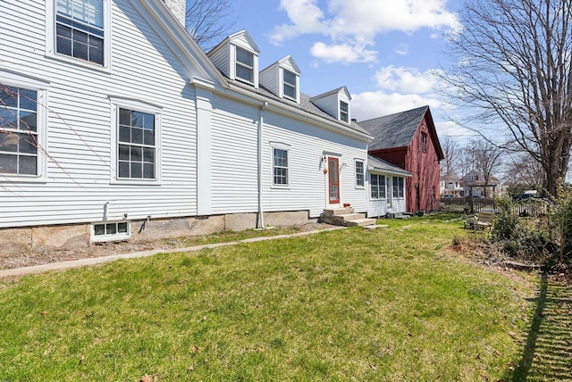 exterior space with entry steps and a yard