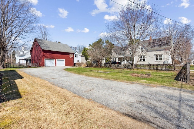 view of street with driveway and a barn