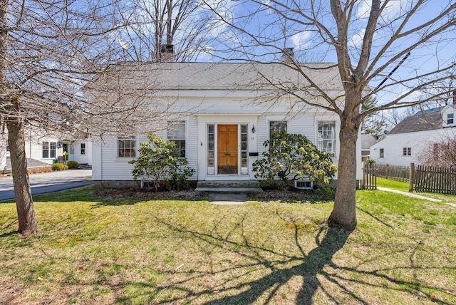 view of front of home featuring a chimney, a front lawn, and fence