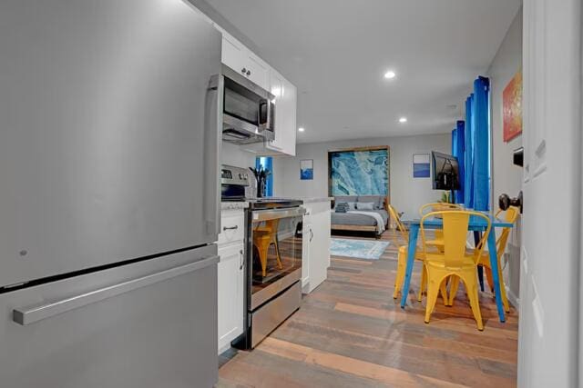 8 College Ave, Gorham, ME 04038 - kitchen featuring stainless steel appliances, white cabinets, light wood-style flooring, light countertops, and recessed lighting
