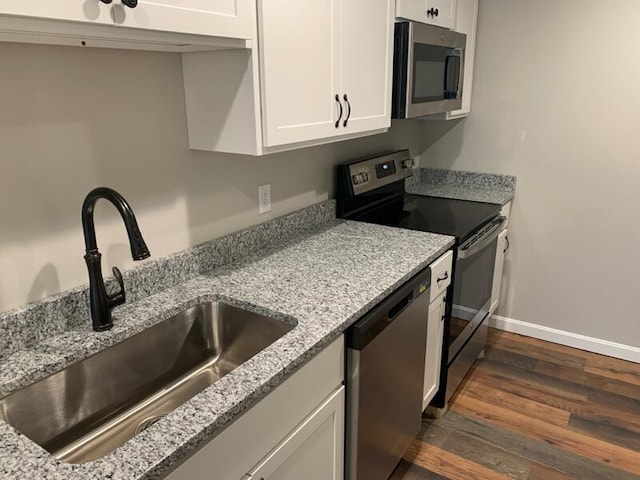 8 College Ave, Gorham, ME 04038 - kitchen with stainless steel appliances, a sink, dark wood-style floors, white cabinets, and baseboards