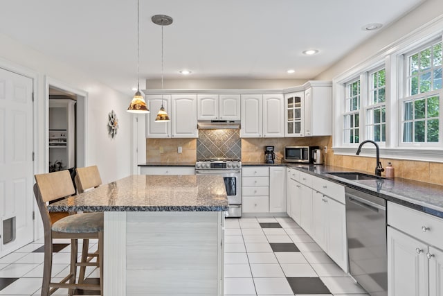 10 Thistleberry Ln, York, ME 03909 - kitchen featuring stainless steel appliances, a breakfast bar area, white cabinetry, tasteful backsplash, and a center island