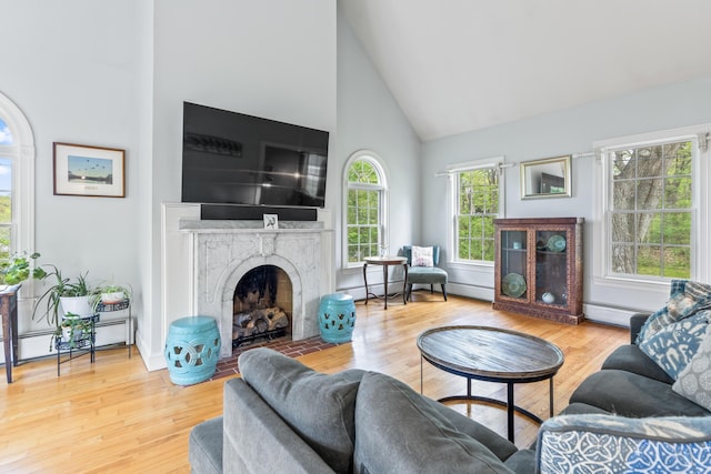 10 Thistleberry Ln, York, ME 03909 - living room featuring high vaulted ceiling, baseboard heating, a fireplace with flush hearth, and wood finished floors