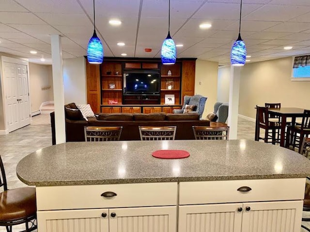 8 Prince St, Lincoln, ME 04457 - interior space featuring decorative light fixtures, a breakfast bar, baseboards, and a kitchen island