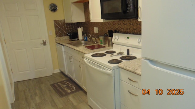 8 Prince St, Lincoln, ME 04457 - kitchen featuring white appliances, white cabinetry, wood finished floors, light countertops, and decorative backsplash