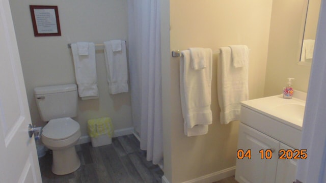 8 Prince St, Lincoln, ME 04457 - bathroom with baseboards, a shower with shower curtain, toilet, vanity, and wood finished floors