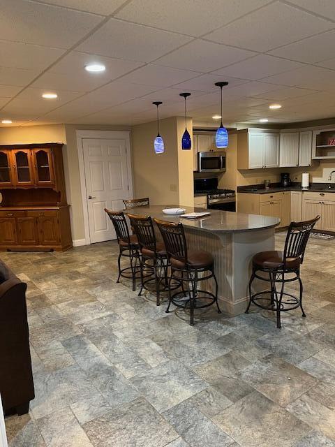 8 Prince St, Lincoln, ME 04457 - kitchen featuring dark countertops, baseboards, recessed lighting, appliances with stainless steel finishes, and a breakfast bar area