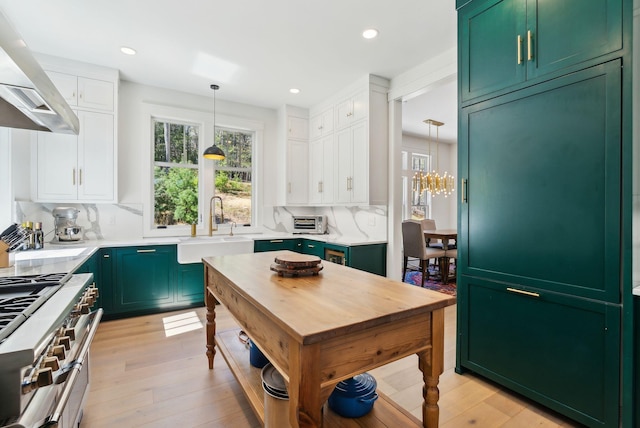 239 Hunter Way, Falmouth, ME 04105 - kitchen with green cabinets, wall chimney exhaust hood, a sink, range with two ovens, and healthy amount of natural light