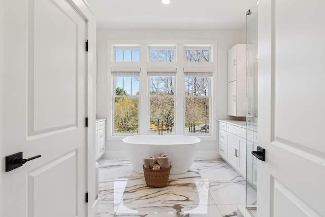 239 Hunter Way, Falmouth, ME 04105 - bathroom featuring marble tiled flooring, a freestanding tub, and recessed lighting