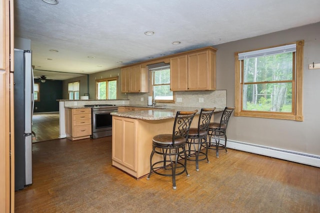 23 Orr St, Wilton, ME 04294 - kitchen featuring appliances with stainless steel finishes, a peninsula, dark wood-type flooring, backsplash, and light stone counters