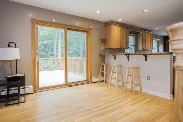 23 Orr St, Wilton, ME 04294 - kitchen with a baseboard heating unit, stone counters, light wood-style floors, a breakfast bar, and recessed lighting