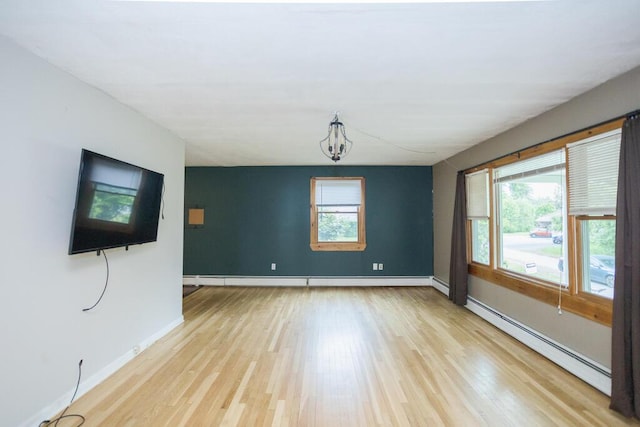 23 Orr St, Wilton, ME 04294 - unfurnished room featuring a baseboard radiator, light wood finished floors, and a chandelier