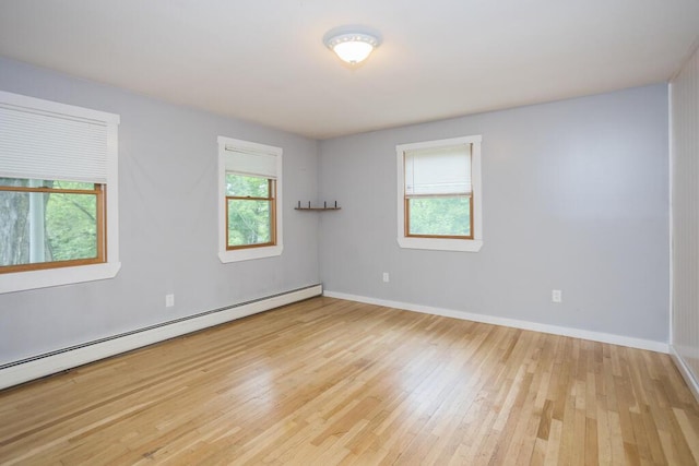23 Orr St, Wilton, ME 04294 - unfurnished room featuring a baseboard radiator, plenty of natural light, and hardwood / wood-style floors