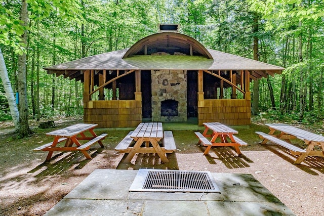 15 Summit Dr, Bridgton, ME 04009 - view of patio / terrace featuring a view of trees and an outdoor stone fireplace