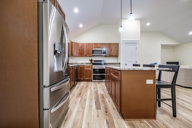 15 Summit Dr, Bridgton, ME 04009 - kitchen featuring light wood-type flooring, appliances with stainless steel finishes, vaulted ceiling, pendant lighting, and a kitchen island