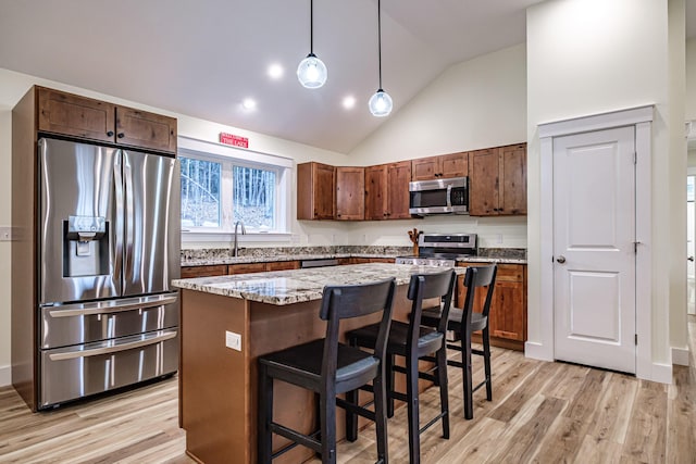 15 Summit Dr, Bridgton, ME 04009 - kitchen featuring light wood-type flooring, appliances with stainless steel finishes, a kitchen island, and lofted ceiling