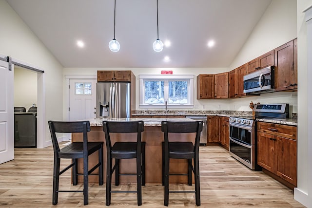 15 Summit Dr, Bridgton, ME 04009 - kitchen featuring a barn door, a breakfast bar area, lofted ceiling, stainless steel appliances, and a sink