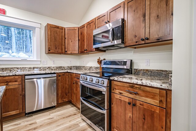 15 Summit Dr, Bridgton, ME 04009 - kitchen featuring stainless steel appliances, light wood finished floors, brown cabinetry, and lofted ceiling