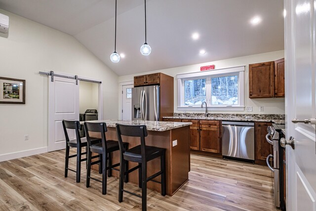 15 Summit Dr, Bridgton, ME 04009 - kitchen with stainless steel appliances, a barn door, light wood-style flooring, and a center island