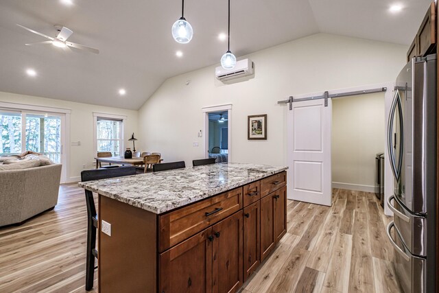 15 Summit Dr, Bridgton, ME 04009 - kitchen with an AC wall unit, freestanding refrigerator, a barn door, a kitchen bar, and lofted ceiling