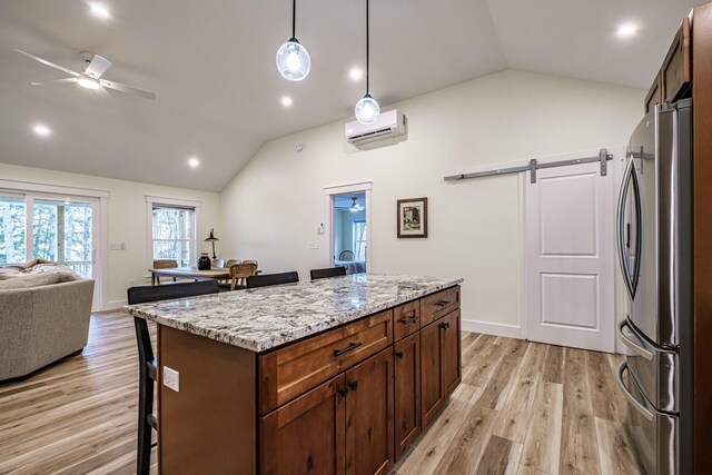 15 Summit Dr, Bridgton, ME 04009 - kitchen with freestanding refrigerator, a kitchen bar, vaulted ceiling, a barn door, and a wall mounted air conditioner