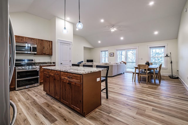 15 Summit Dr, Bridgton, ME 04009 - kitchen featuring ceiling fan, light wood-type flooring, stainless steel appliances, a breakfast bar area, and lofted ceiling