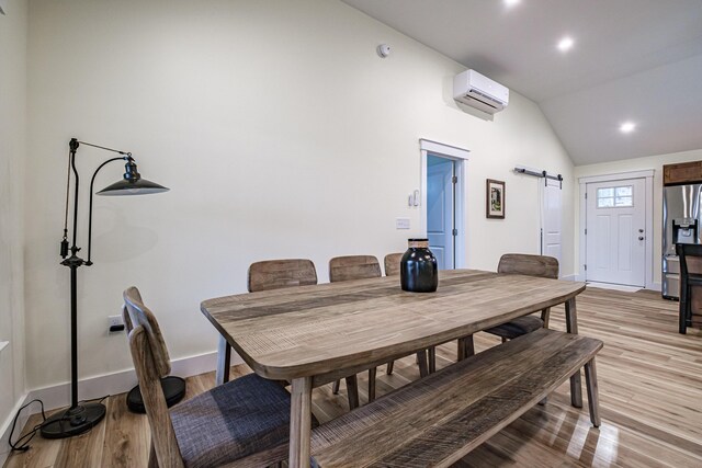 15 Summit Dr, Bridgton, ME 04009 - dining room featuring a wall mounted AC, baseboards, a barn door, lofted ceiling, and light wood finished floors