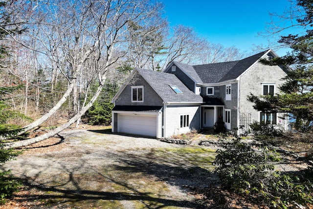 view of property exterior featuring an attached garage, a shingled roof, and driveway