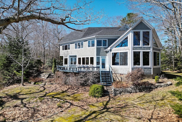 rear view of house featuring a shingled roof, stairs, and a wooden deck